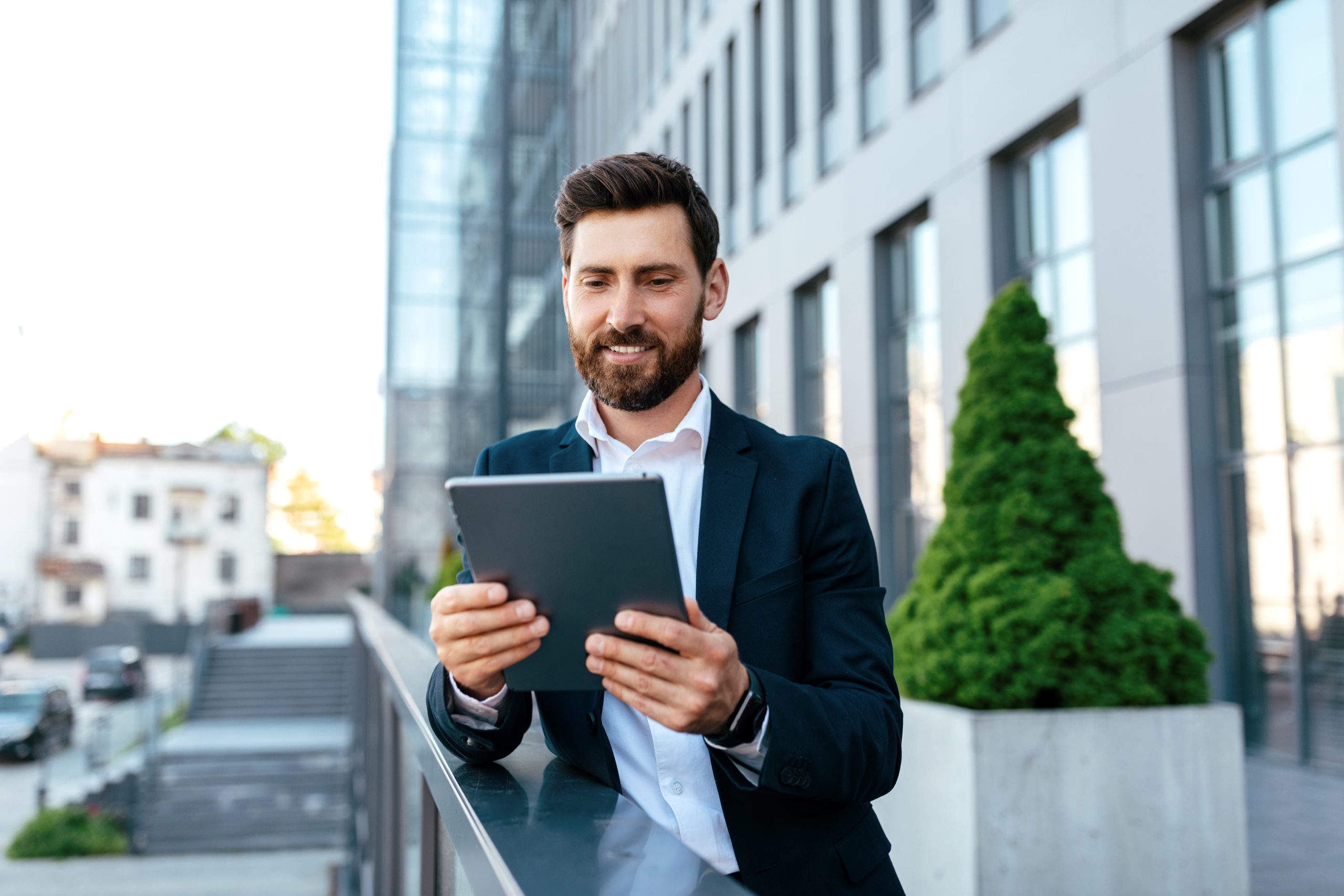 A man standing in a balcony and carrying a tablet