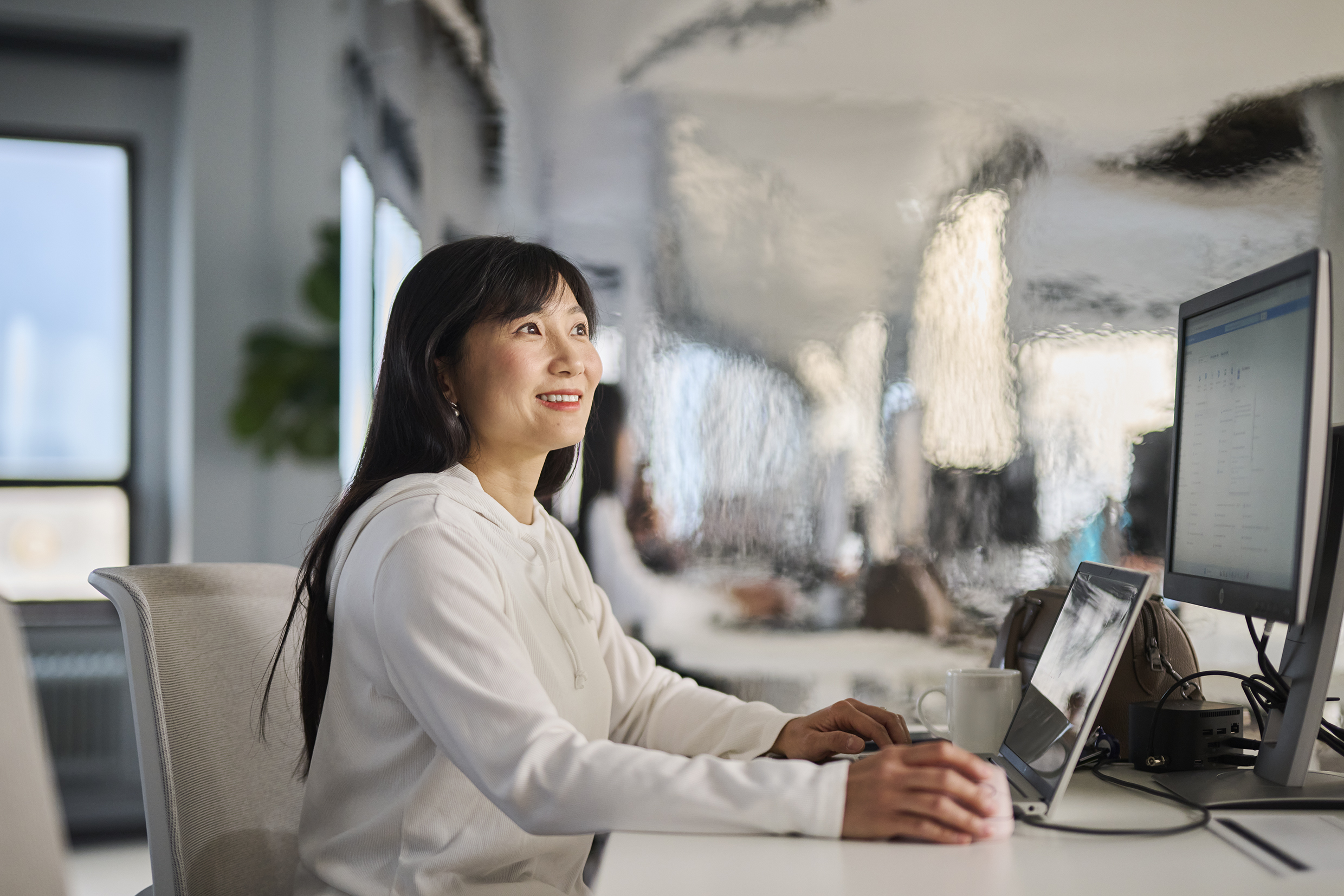 Young Woman Data Scientist Working On Computer and using mouse with right hand.