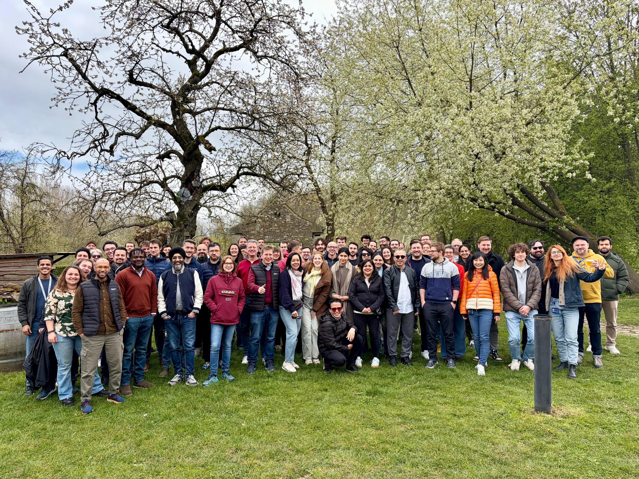 Group of people from Proximus Ada taking joyful picture and raising their hands